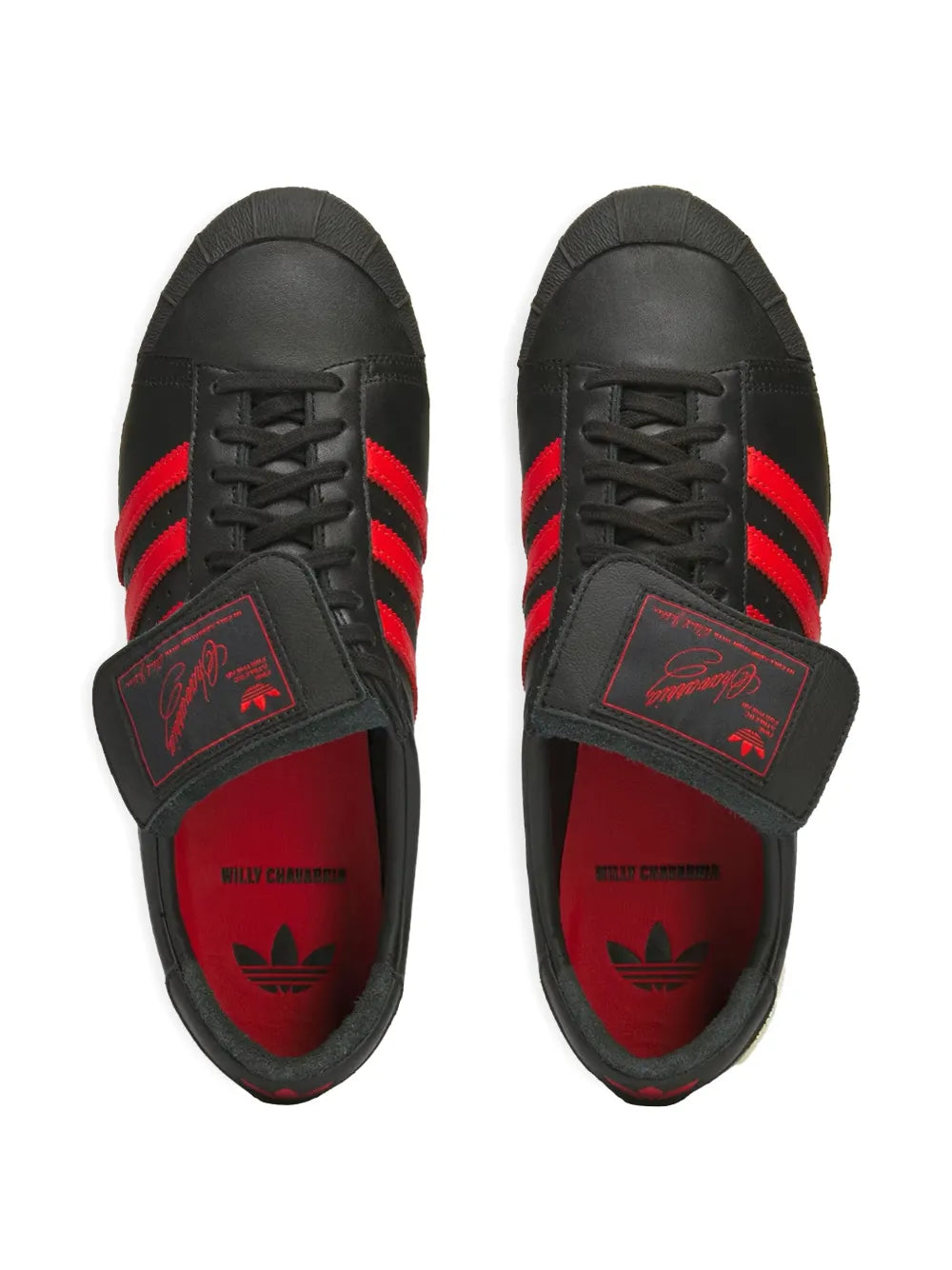 Black low-top adidas sneakers with red stripes, red lining, and lace-up fronts