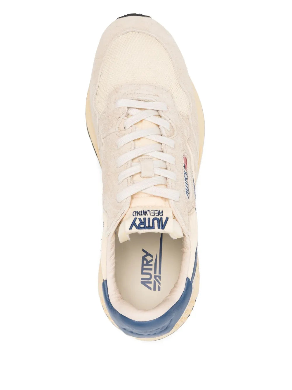 Beige lace-up sneaker showing tongue logo and navy lining