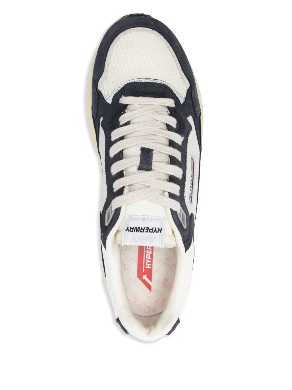 White and navy lace-up sneaker showing tongue and interior brand label