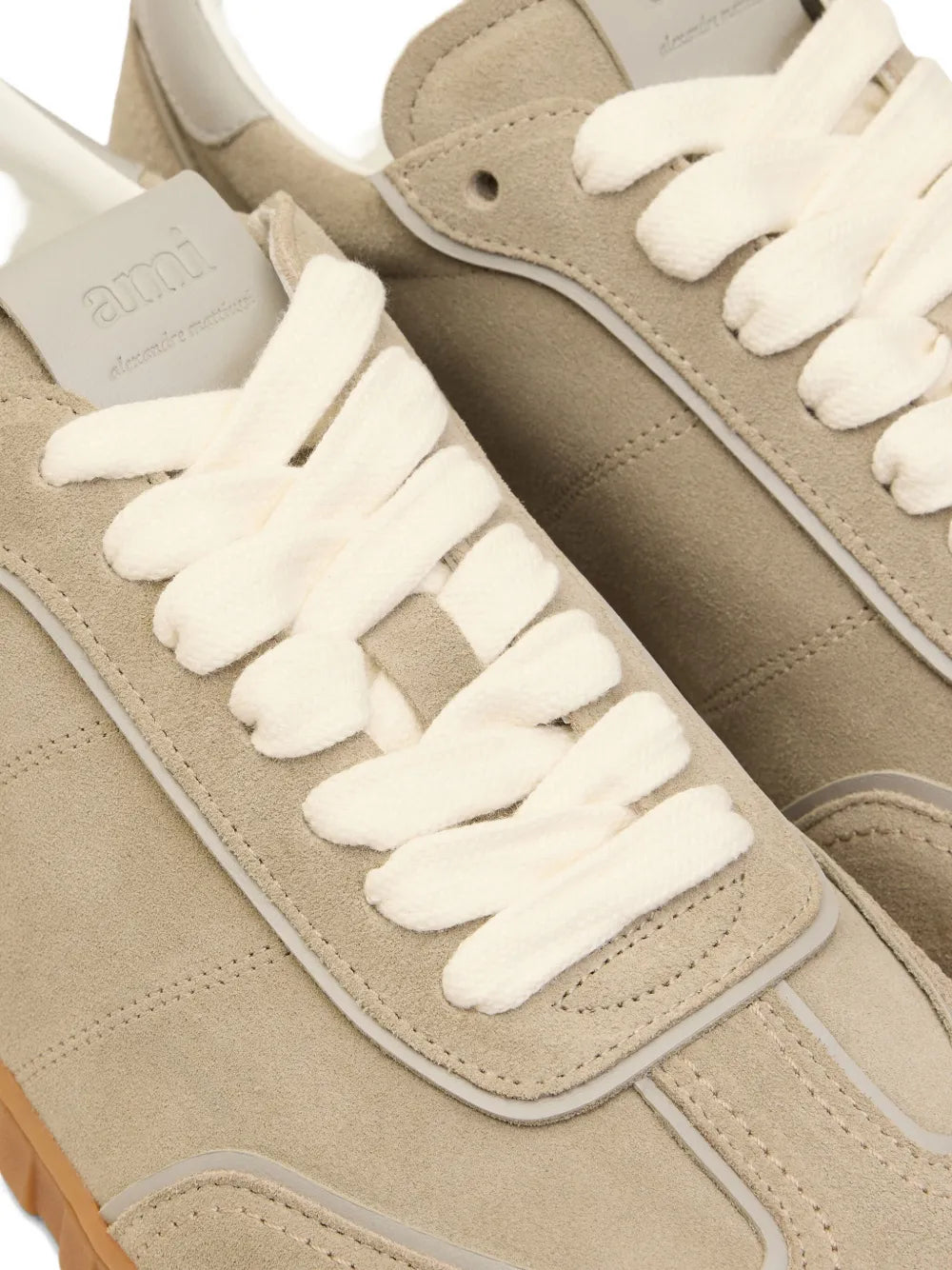 Close-up of beige leather low-top sneakers with white laces and side stitching