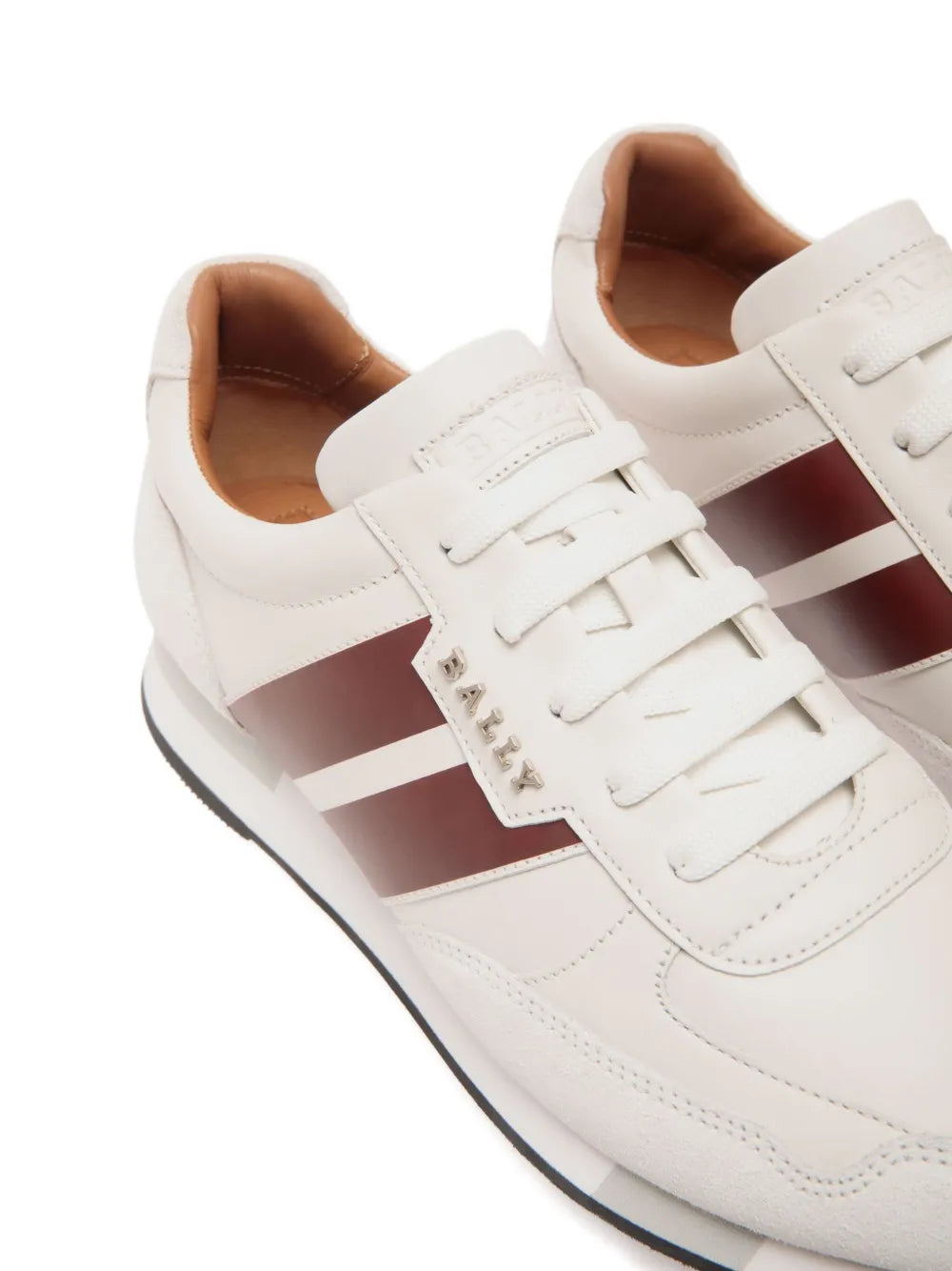 White leather sneaker close-up: lace-up front with burgundy stripe and stitched detailing