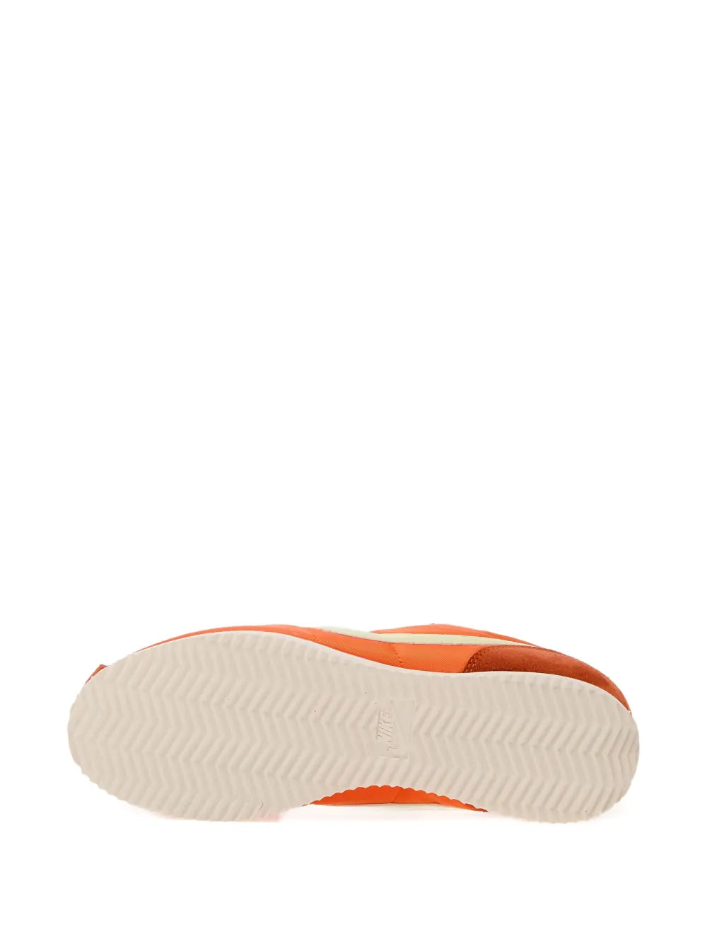 Orange low-top sneaker outsole with textured traction tread, cream rubber