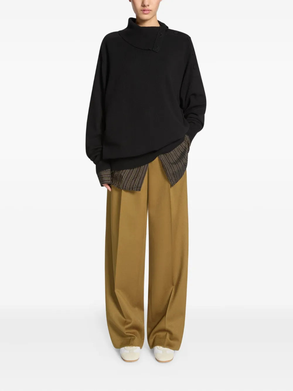White suede-panelled sneakers peeking under wide-leg trousers