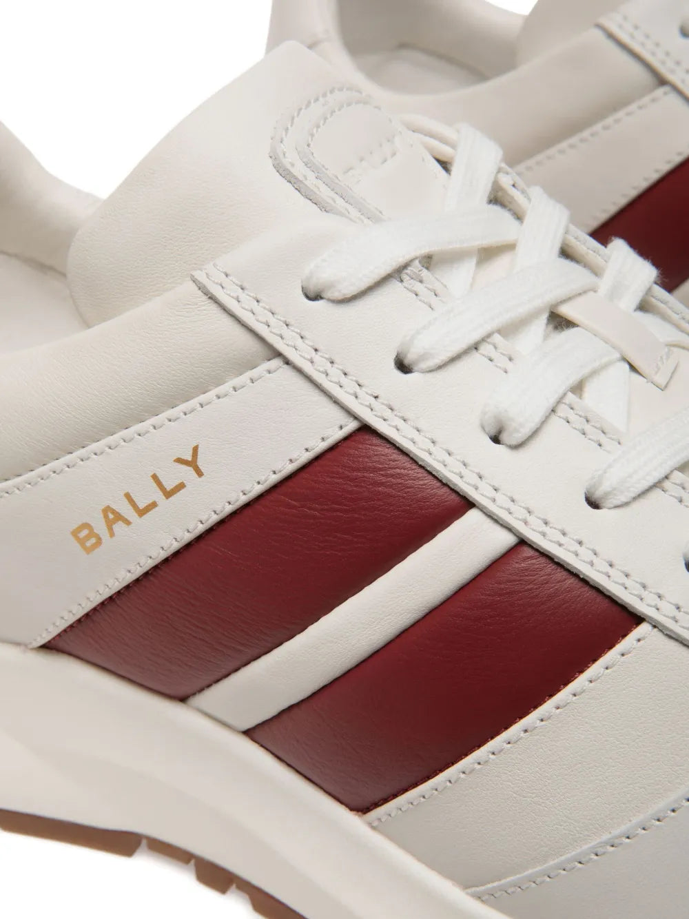 Close-up of Bally white leather sneakers with lace, burgundy panel, and logo