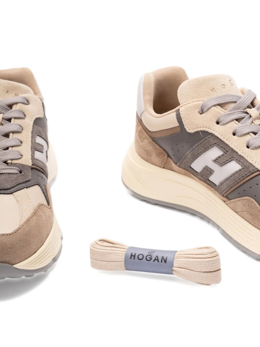 Beige sneakers close-up of laces, side logo and striped H pull tab