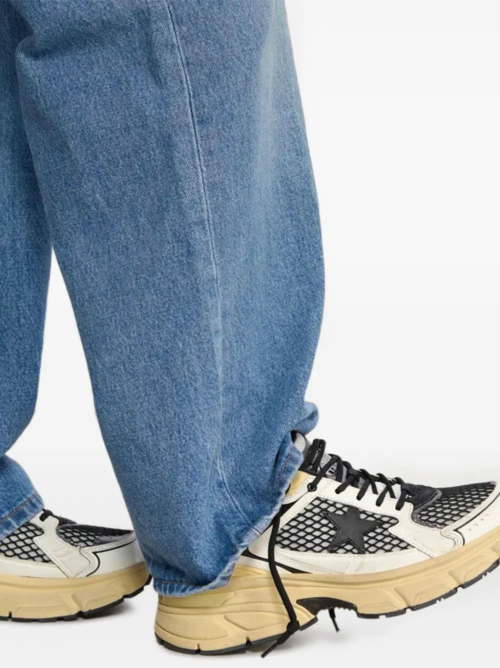 Golden Goose Lightstar sneakers on blue jeans, black laces and cream sole