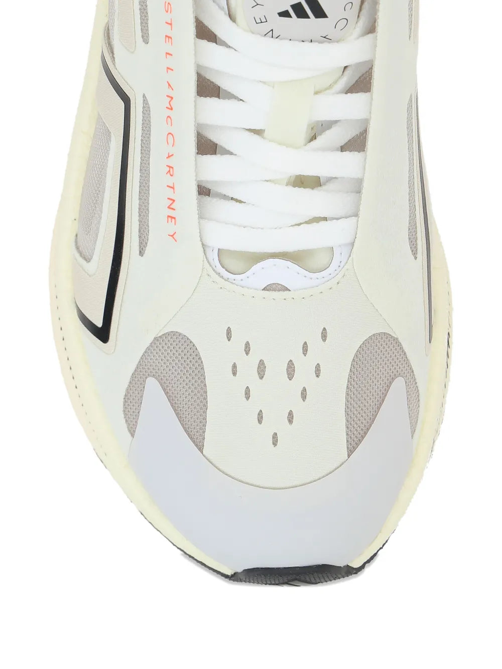 White mesh sneaker close-up with lace-up front, gray cage detail and perforated panels