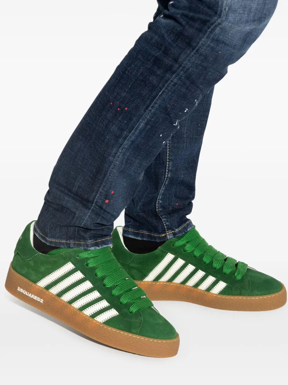 Green suede sneakers with white striped sides, green laces, worn with jeans and gum sole.