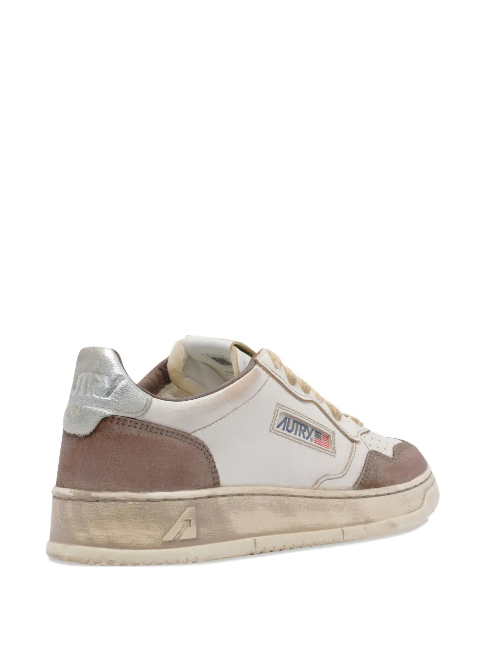 Side view of white and brown leather sneakers with lace-up front and rear logo.
