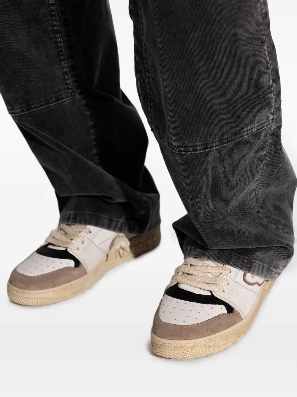 Leather sneakers in white and brown worn with dark jeans, lace-up with low sole