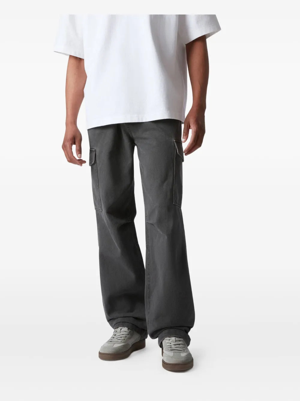 Light gray suede sneakers worn with dark gray trousers