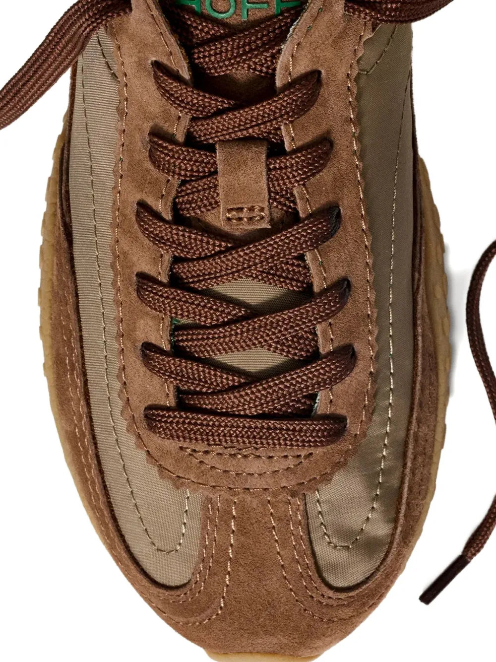 Close-up of brown suede-style lace-up sneaker with stitched panels