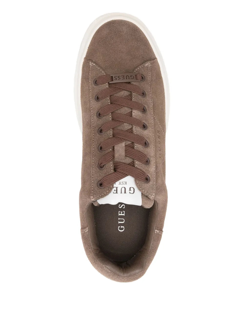 Brown suede lace-up sneaker close-up with Guess logo on tongue, white edge sole