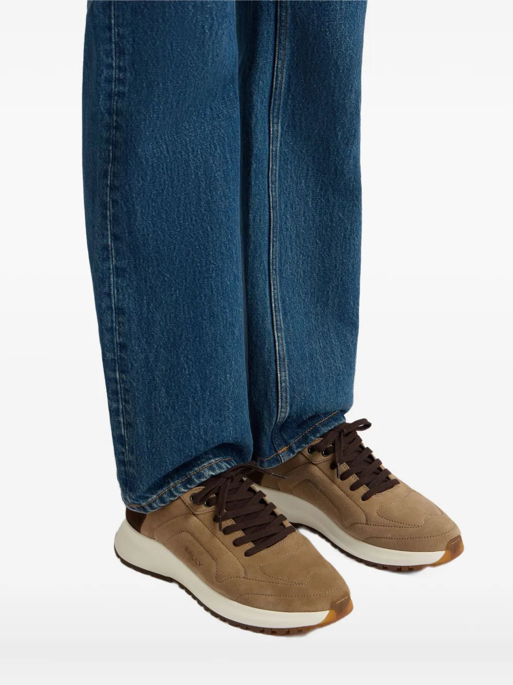 Taupe suede lace-up sneakers with dark laces and white sole, worn with jeans