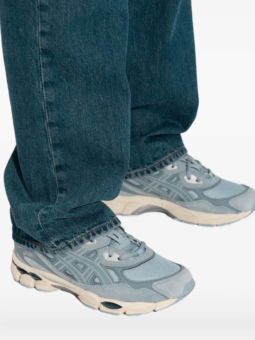 Light blue ASICS sneakers with blue jeans, side profile and rubber outsole