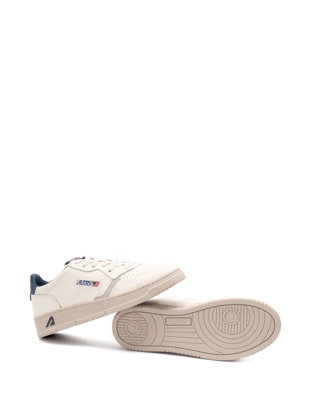 Light beige sneakers with navy heel tab; side profile and gum-style outsole