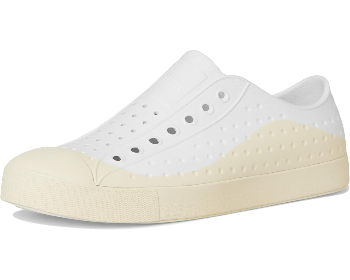 Front 3/4 view of white and bone slip-on sneaker with perforated upper and platform sole