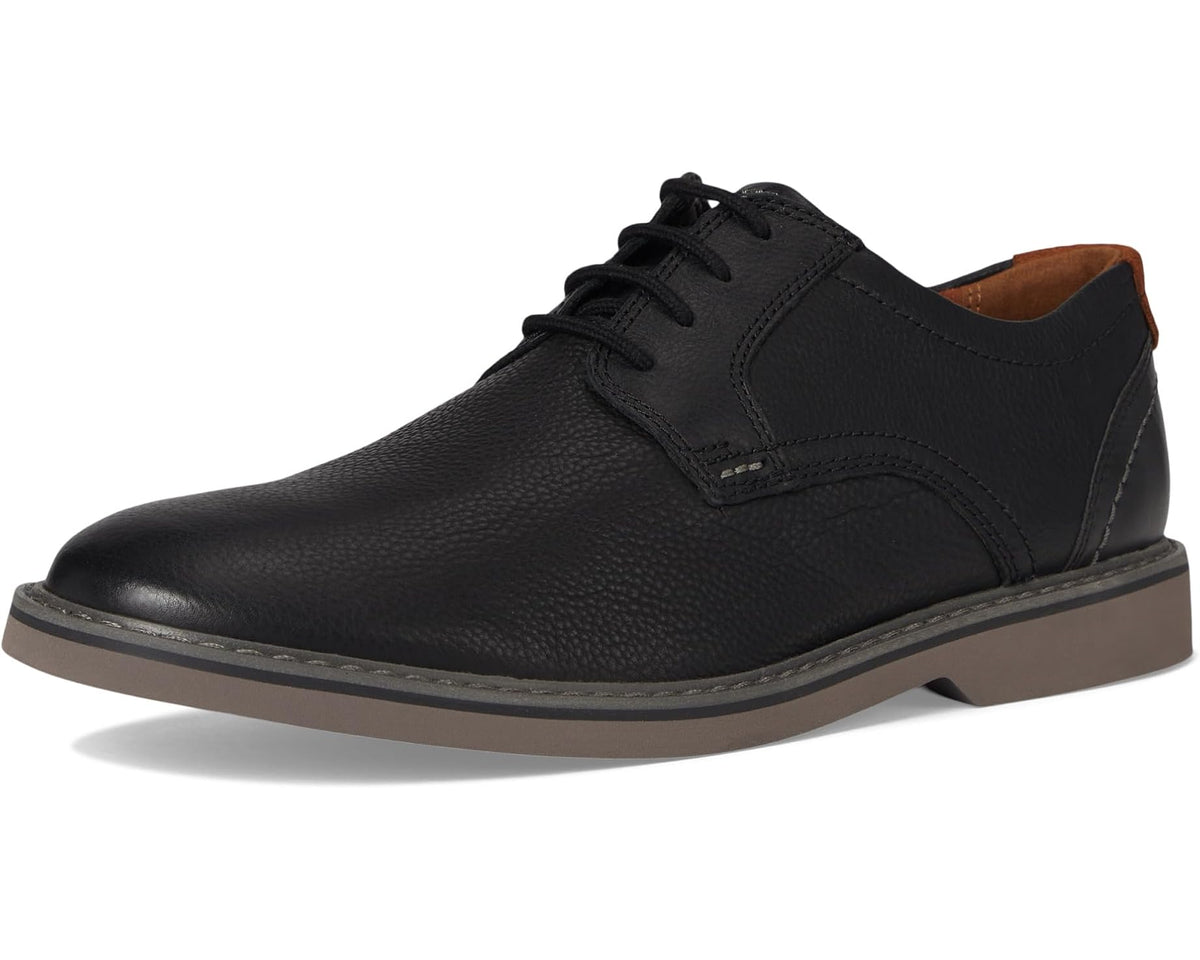 Black leather low-top lace-up shoe with padded collar and brown outsole edge