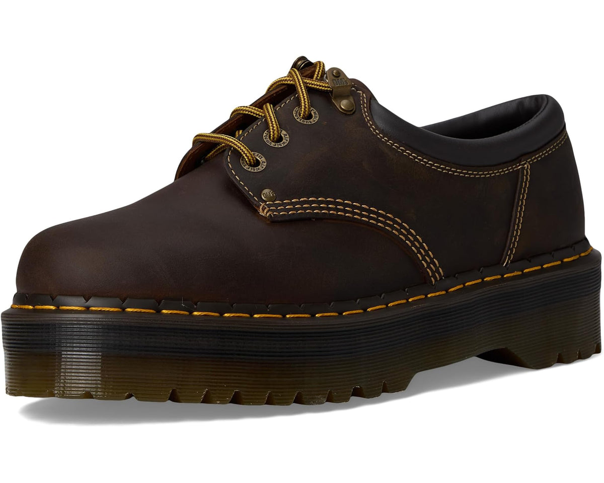 Dark brown unisex lace-up shoe with rounded toe, yellow stitching, and platform sole