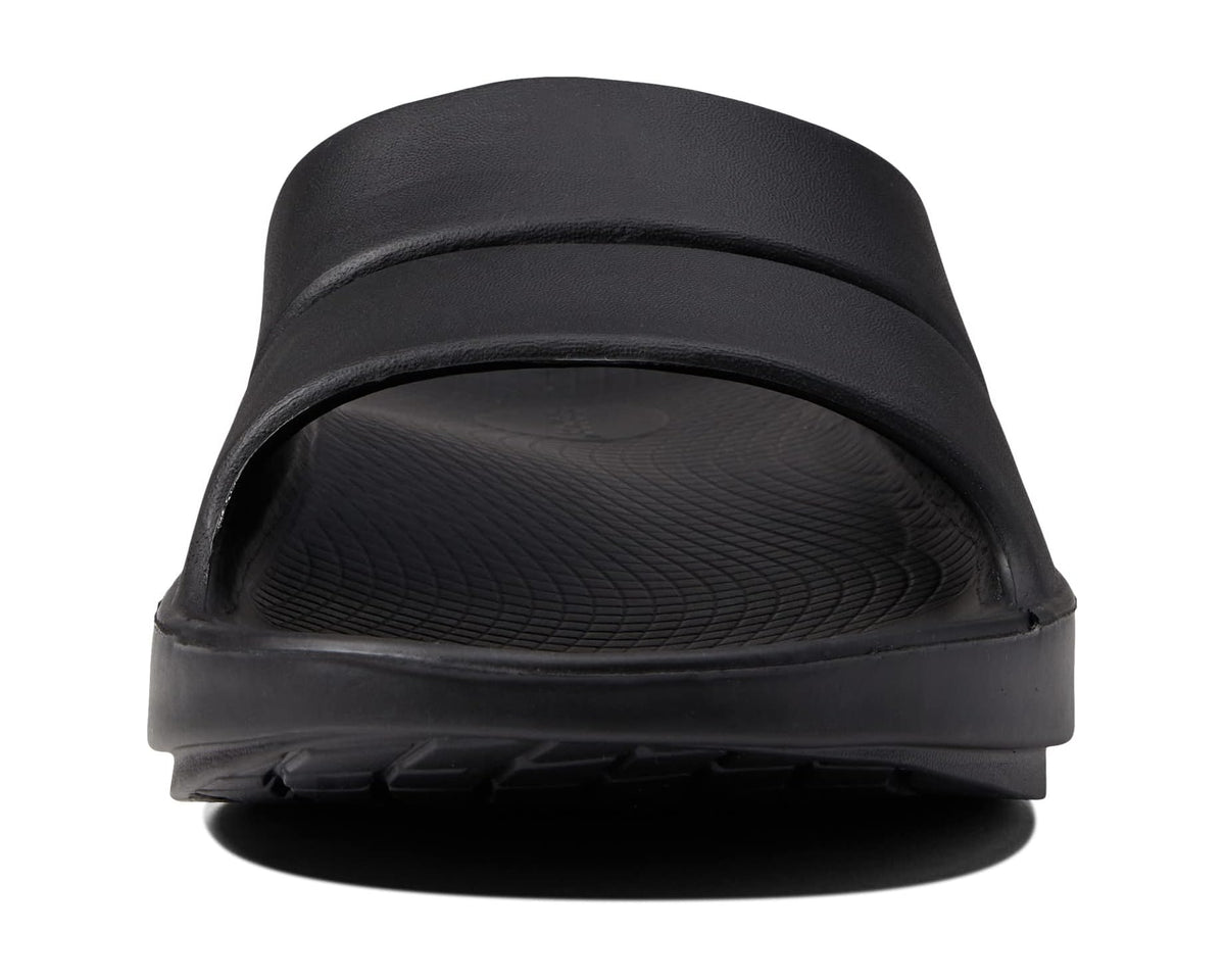 Black OOahh slide sandal front view with cushioned band and molded tread