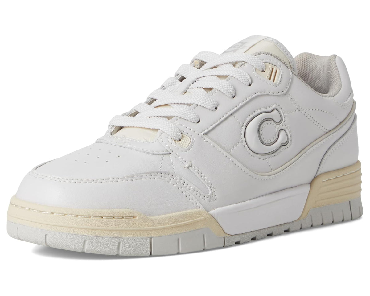 Front/side view of optic white COACH Soho sneaker with lace-up, logo emblem, and tan sole