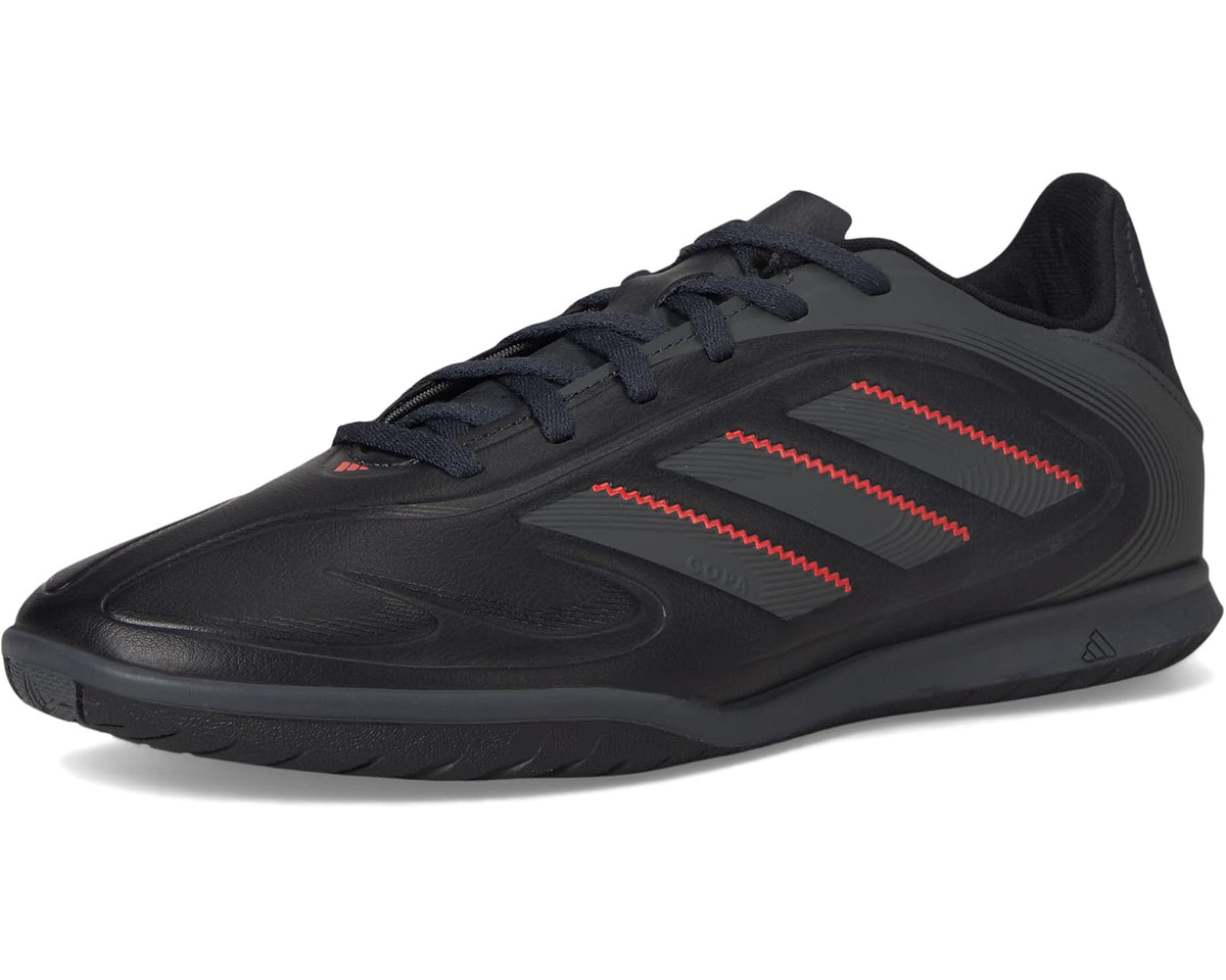 Black adidas unisex indoor soccer shoes, front three-quarter view with red stripe detailing
