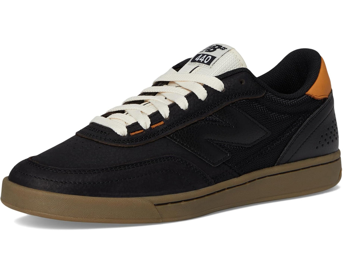 Black low-top skate sneaker with white laces, orange accents, gum sole