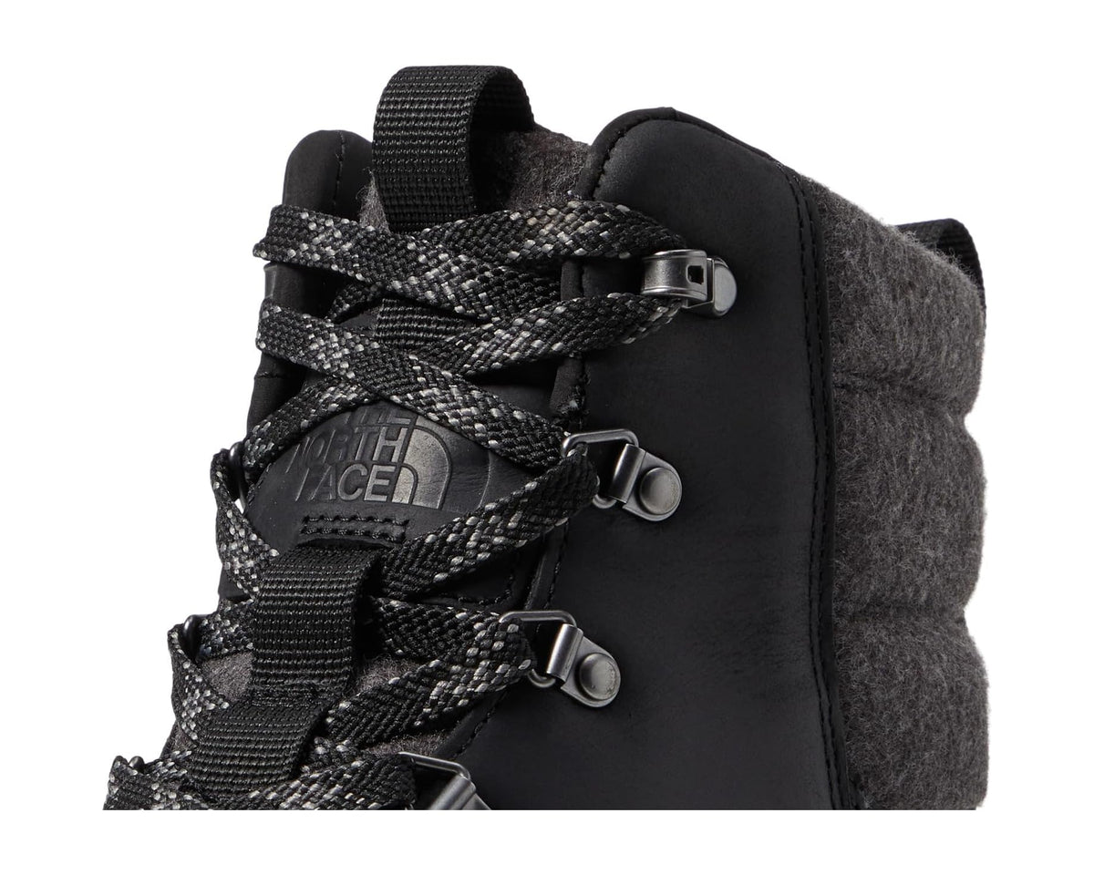 Black waterproof leather boot close-up with lace straps and TNF logo
