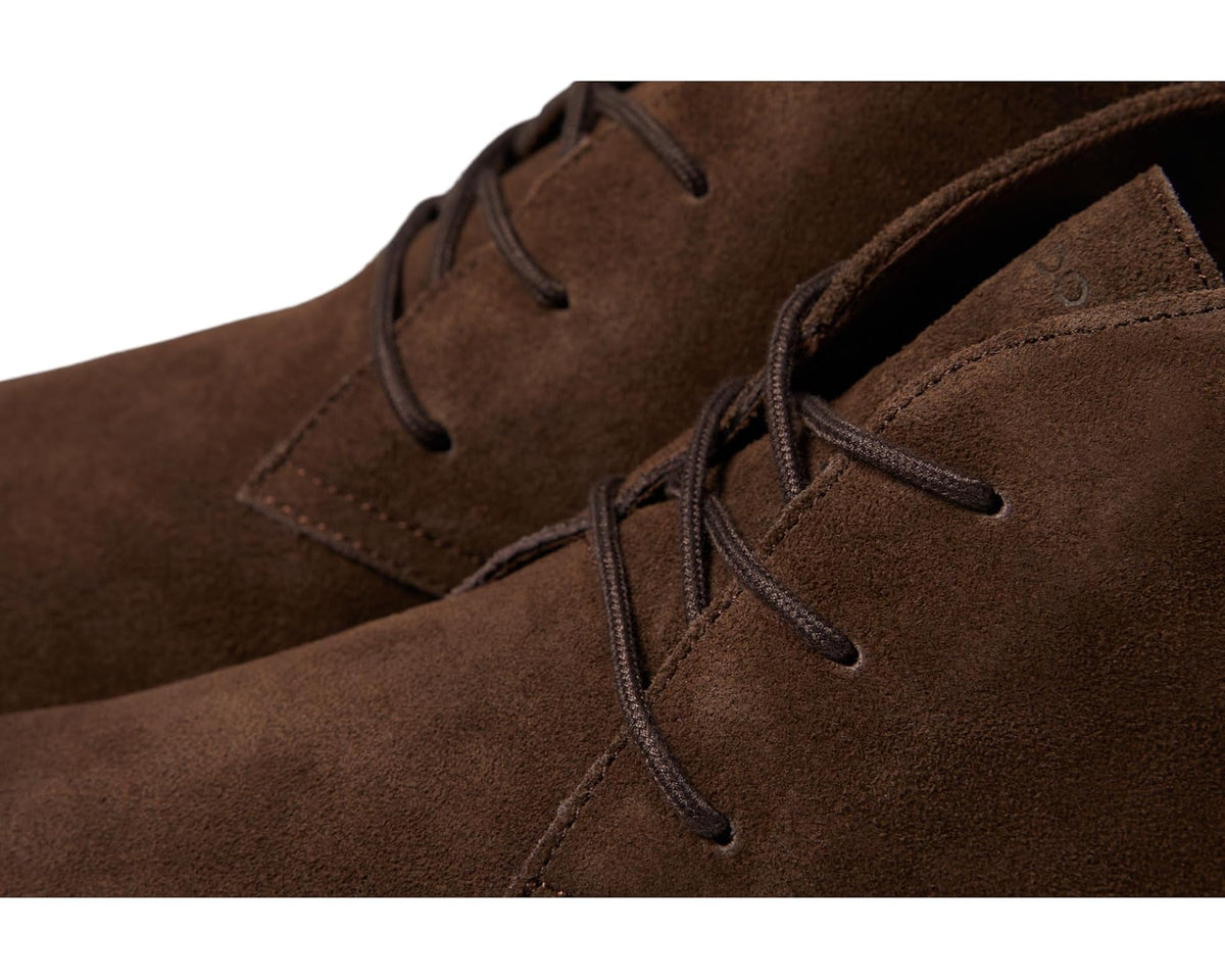 Close-up of brown suede lace-up boot with stitched eyelets