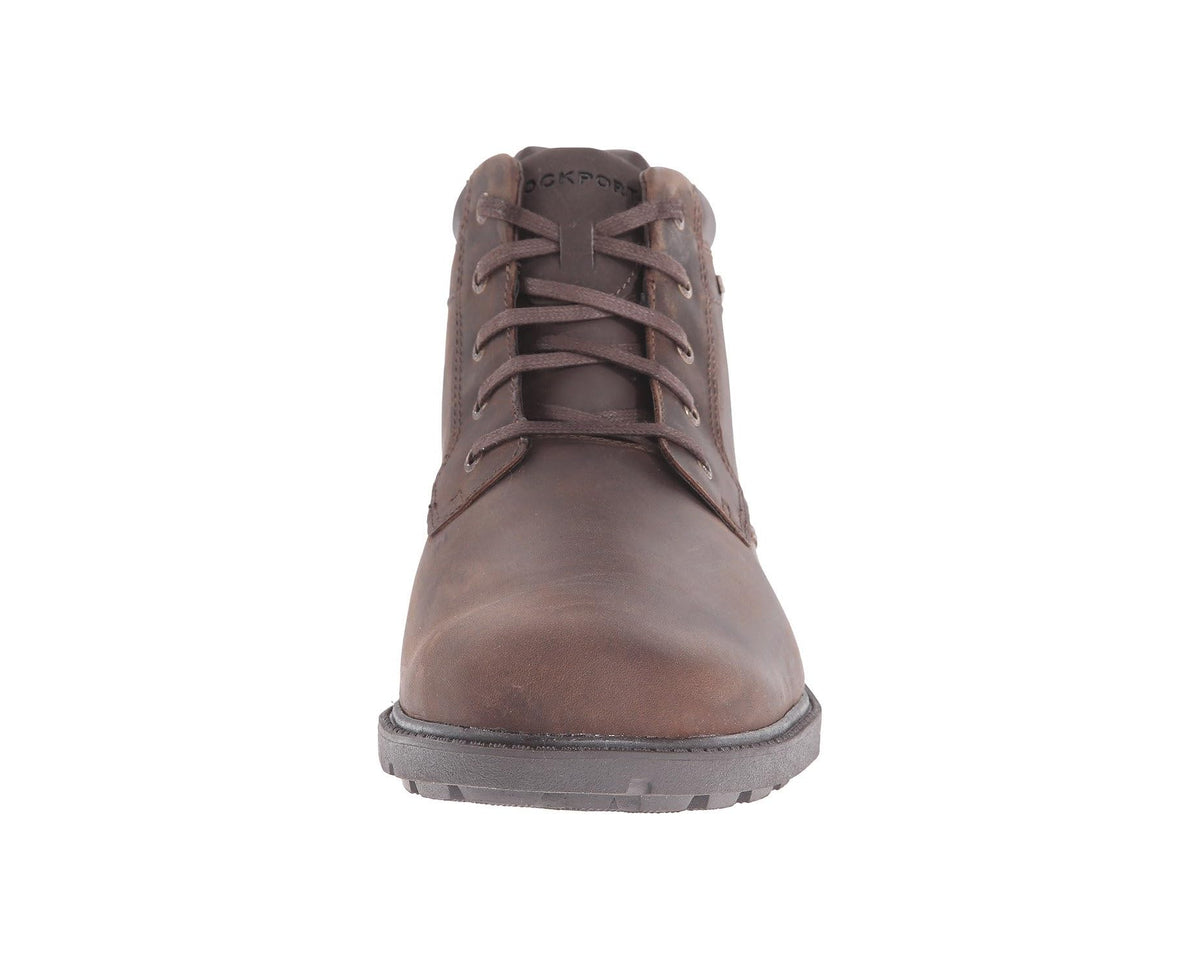 Tan lace-up boots with rounded plain toe, padded tongue, and textured rubber sole