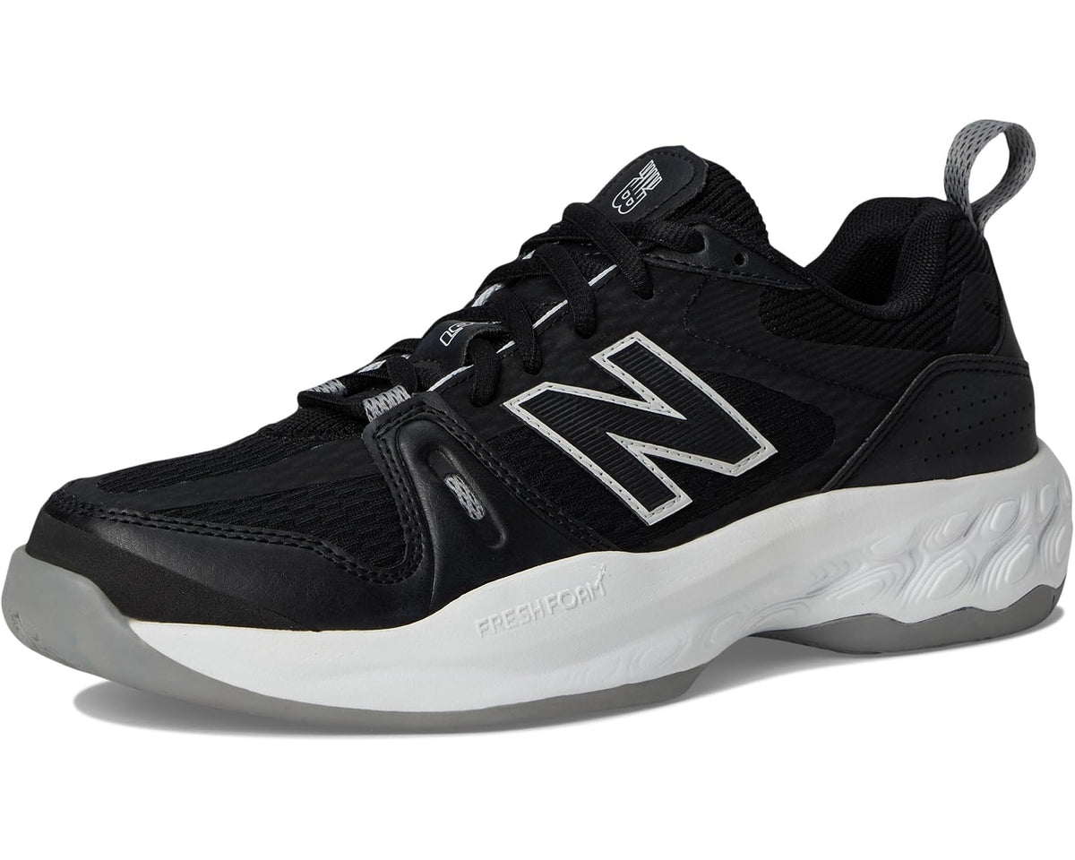 Black New Balance tennis shoe front three-quarter view, white midsole and silver N logo