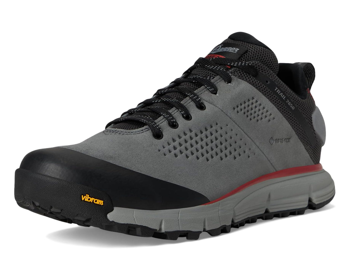 Grey trail boot with black laces, red trim, and Vibram-branded sole.
