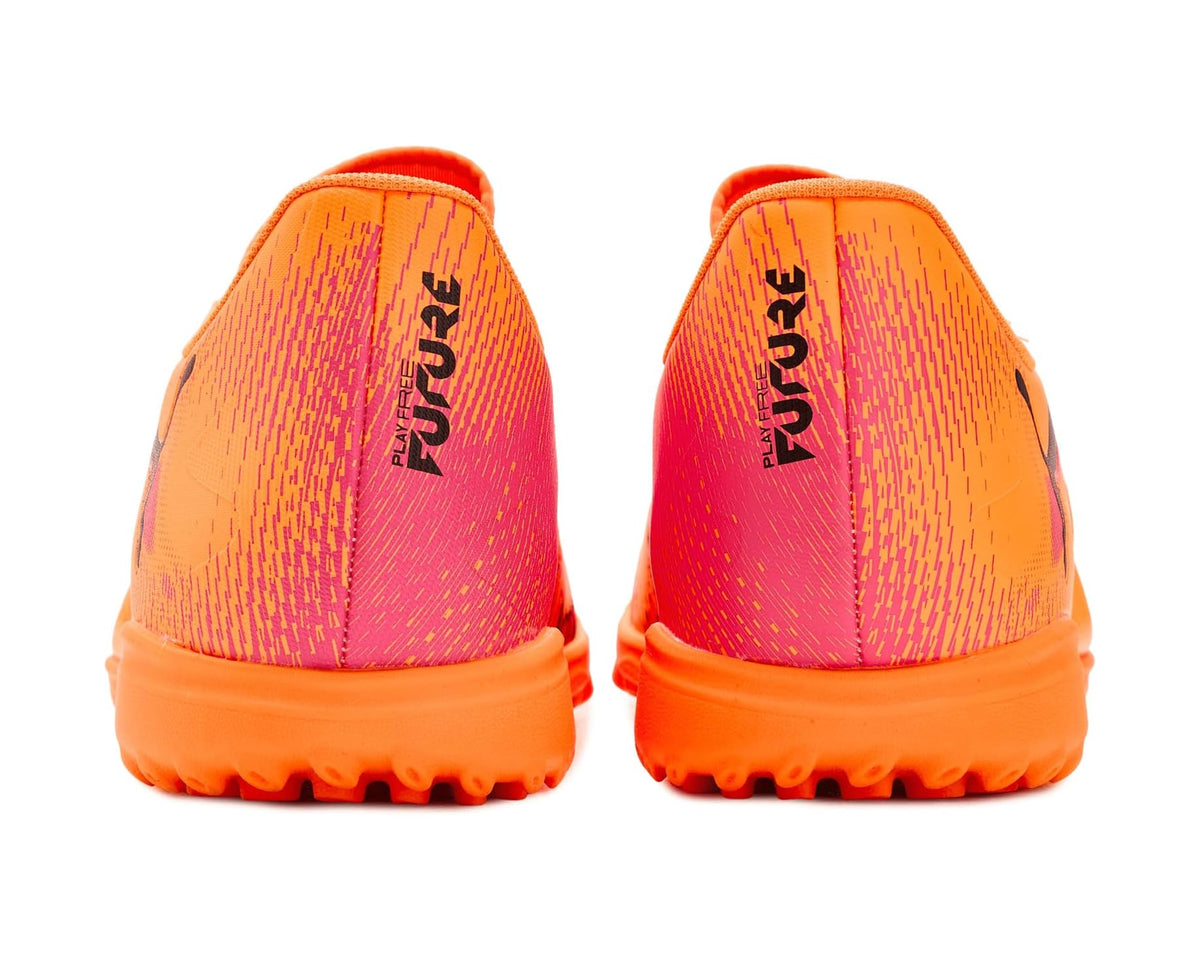 Orange PUMA turf cleats rear view with pink text graphic and orange outsole