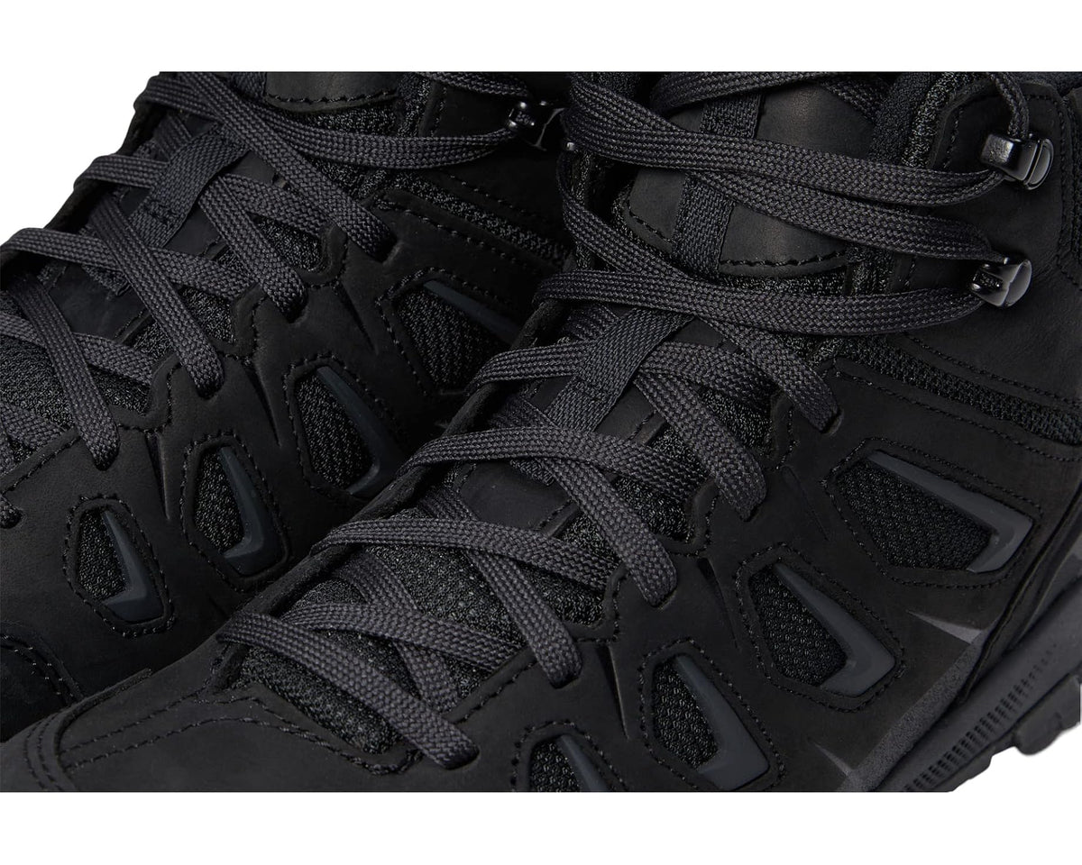 Black boot upper close-up with lace rows and textured overlay panels