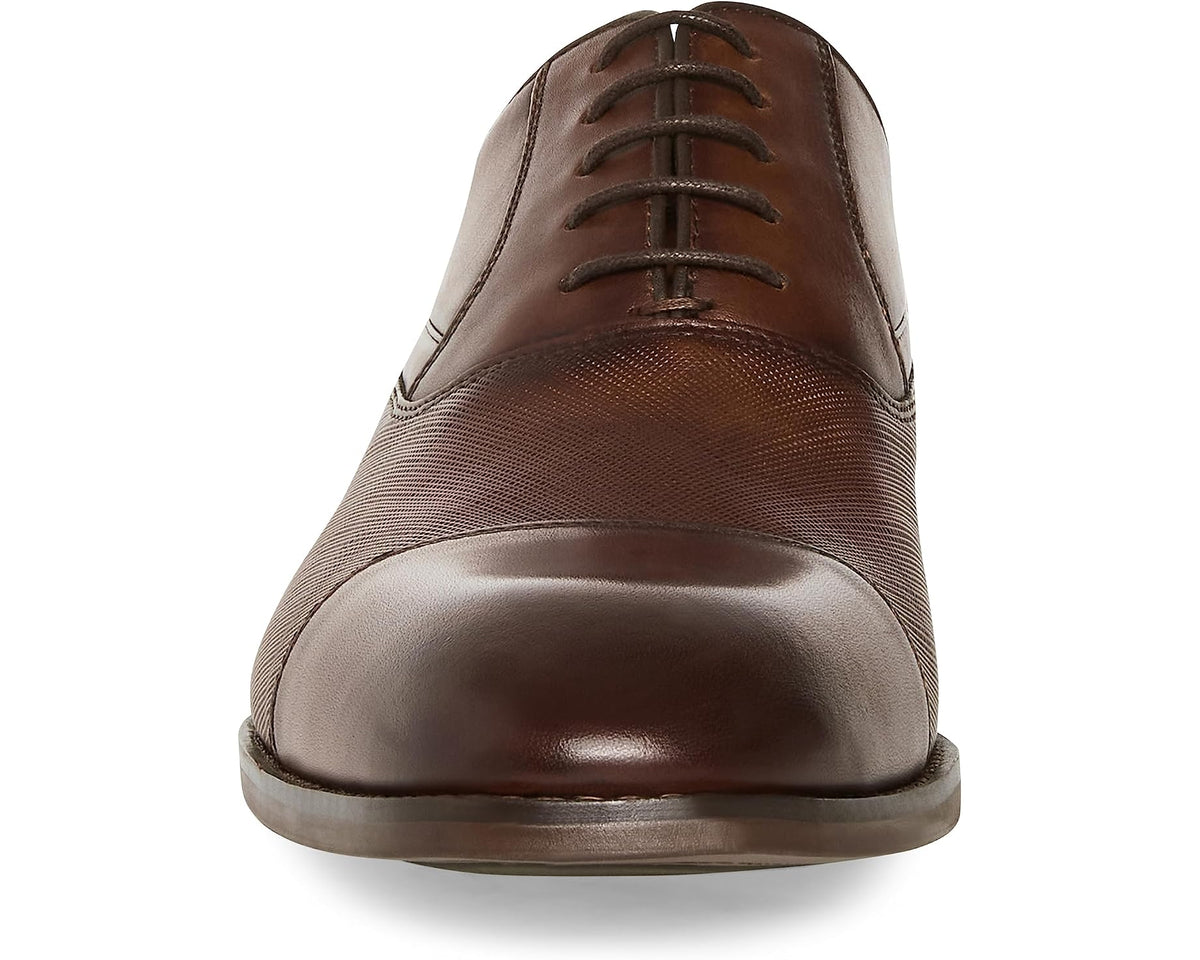 Tan leather Oxford dress shoe front view with lace-up and rounded toe.
