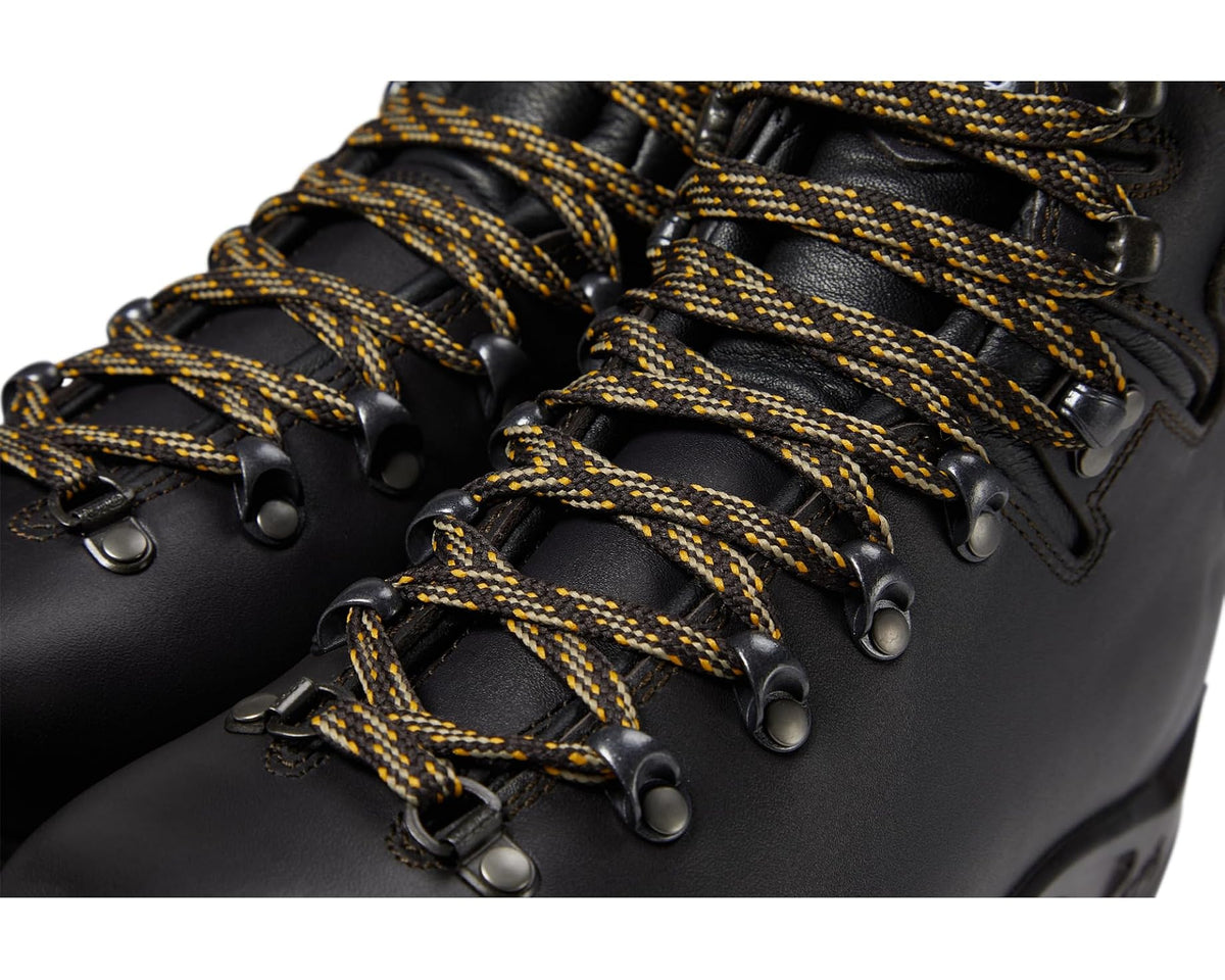 Close-up of dark leather hiking boot with gold-and-black woven laces and metal eyelets