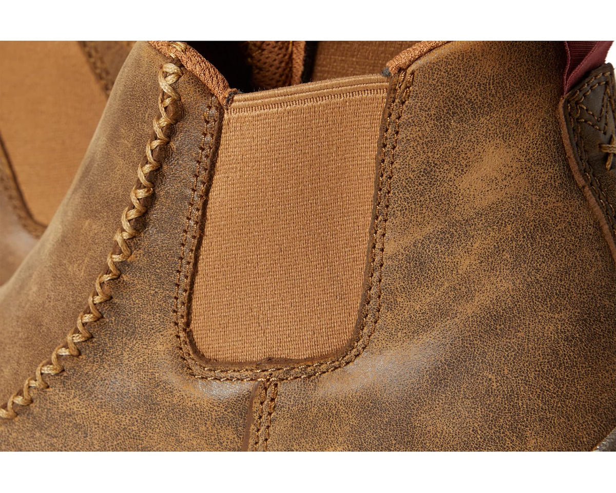 Close-up of tan suede upper with elastic side panel and stitched seam