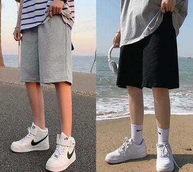 Gray and black straight sports shorts, each with a small white logo graphic on the leg