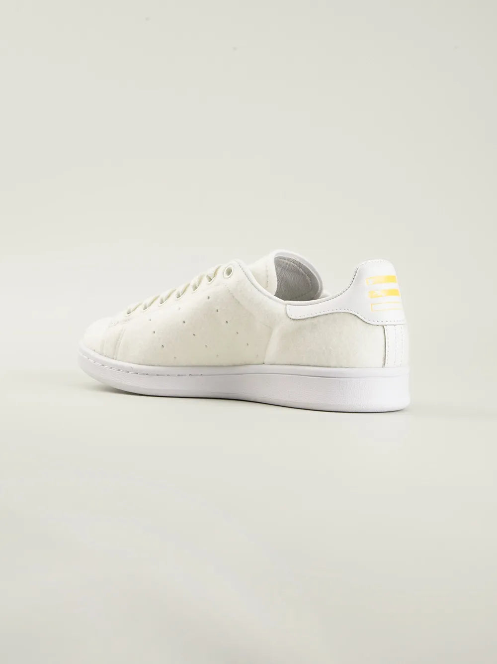 White low-top sneakers with yellow and gray heel panel detail