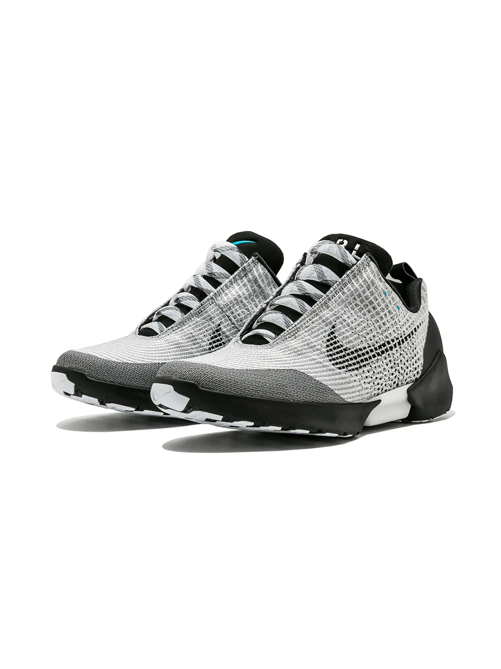Sneaker pair side view with white mesh-knit upper, black pods, and treaded outsole