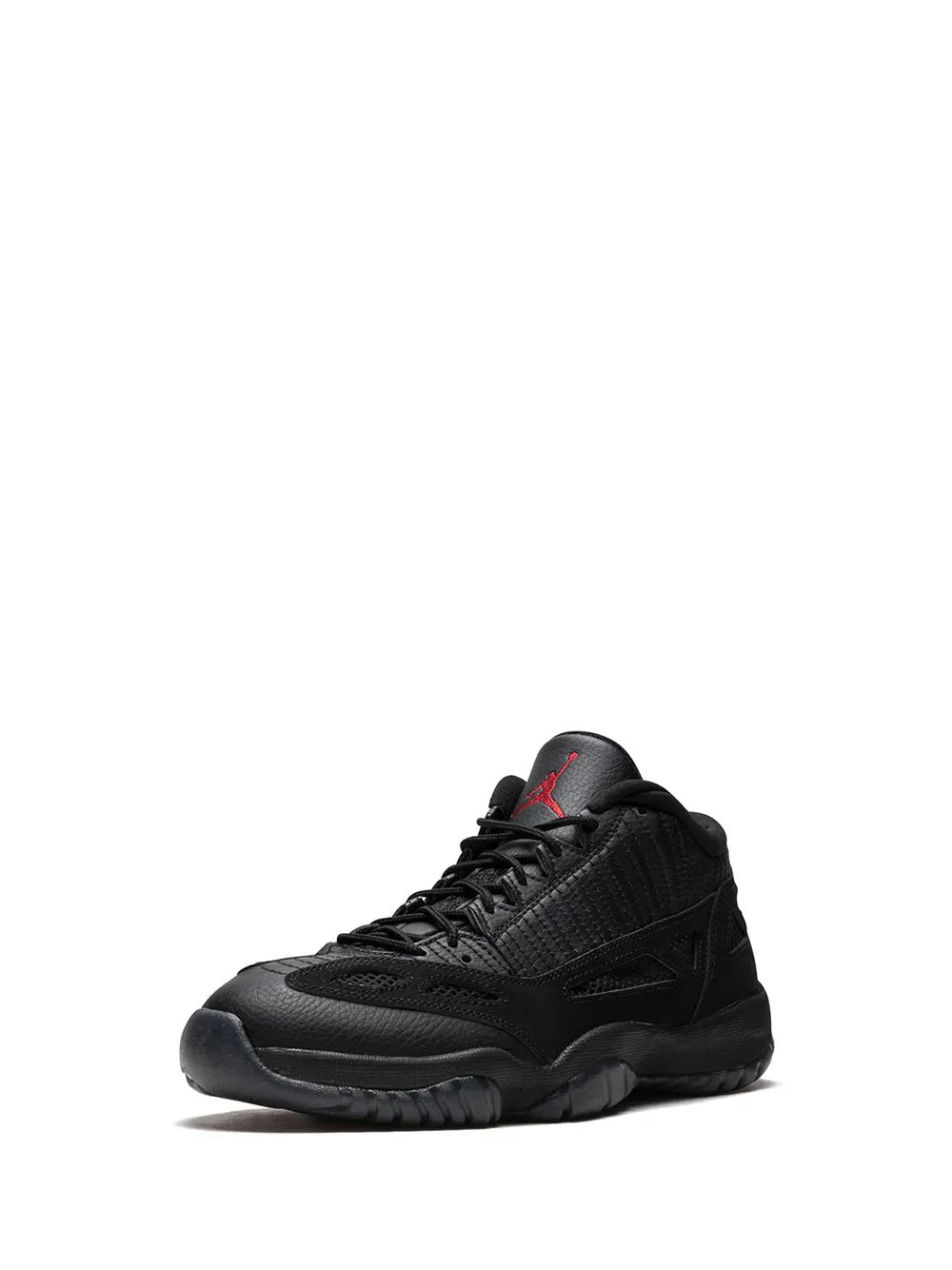 Black low-top sneakers in front view with red accent at tongue