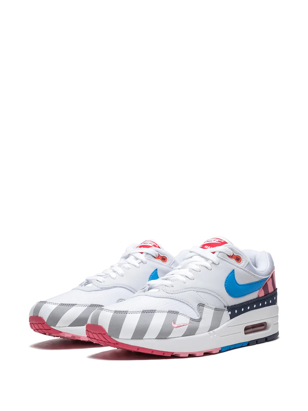 White sneakers with blue swoosh, red heel tabs, gray toe stripes, visible air unit