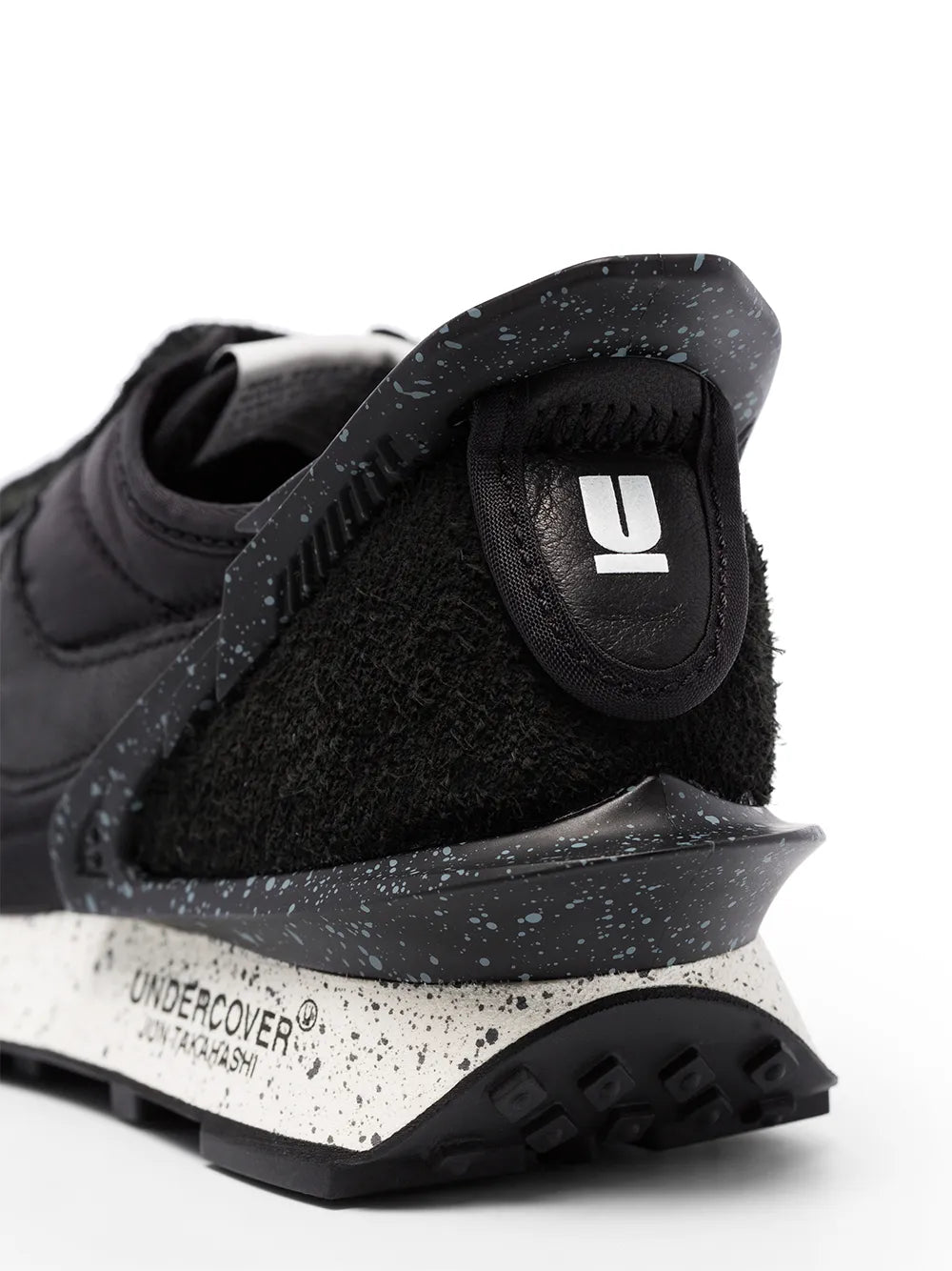 Black Nike x Undercover Daybreak sneaker close-up, speckled sole and U logo
