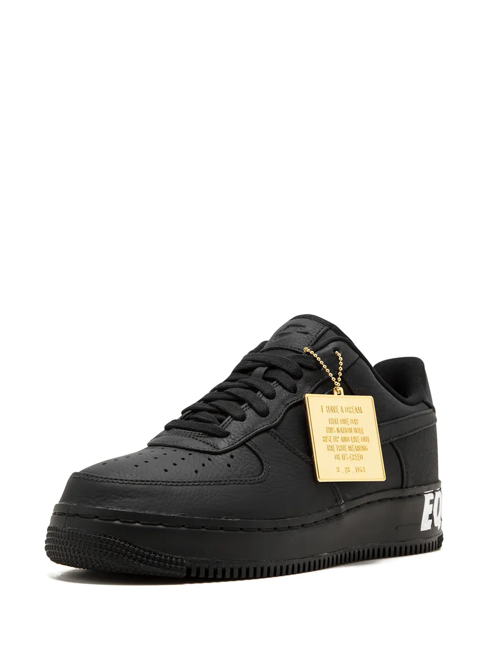 Black low-top sneakers with gold hang tag, lace-up front, perforated toe