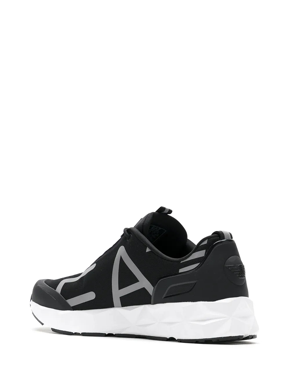 Black low-top sneakers with logo stripe on side and heel tab, black laces, white sole