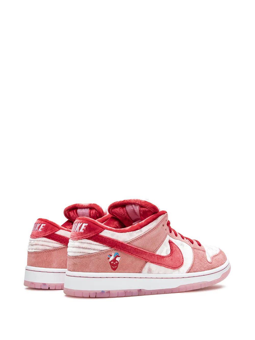 Low-top skate shoes with red heel tab, white side stripes and pink upper