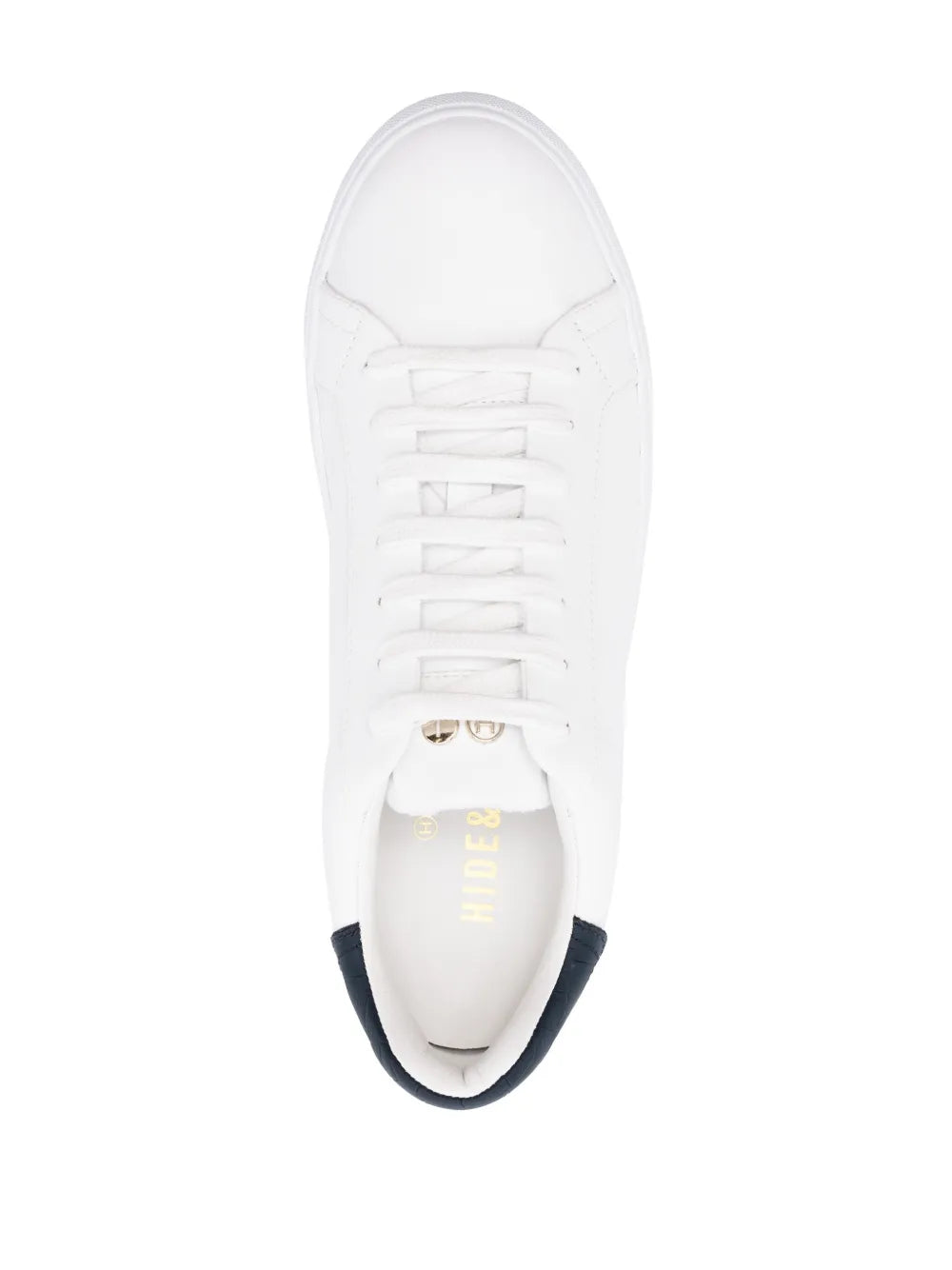 White low-top sneakers with white laces and dark lining at the heel