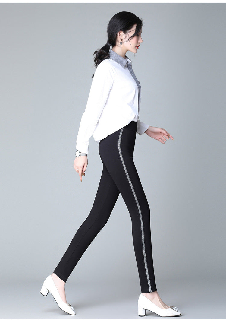 Black slim pants with vertical white side stripes and ankle-length tapered cut