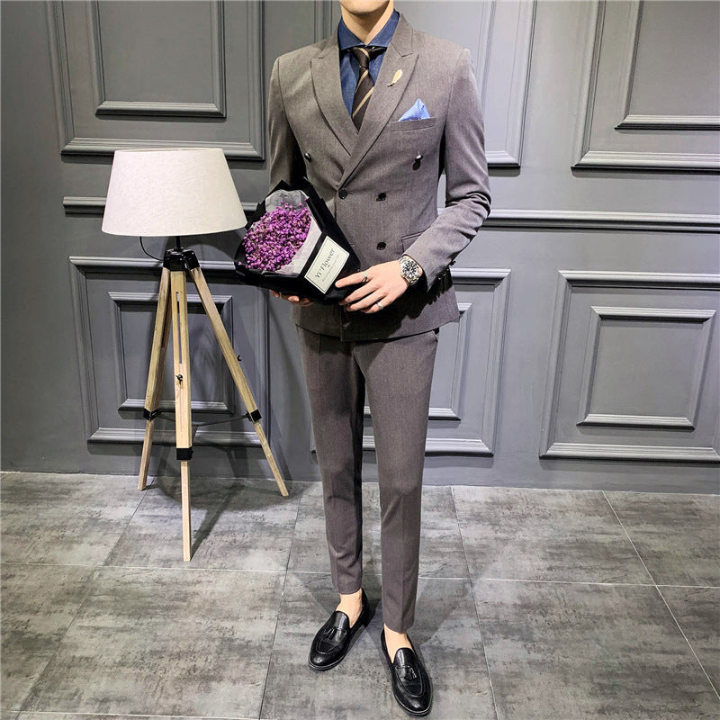 Men's gray double-breasted suit with pocket square, dark shirt and slim trousers