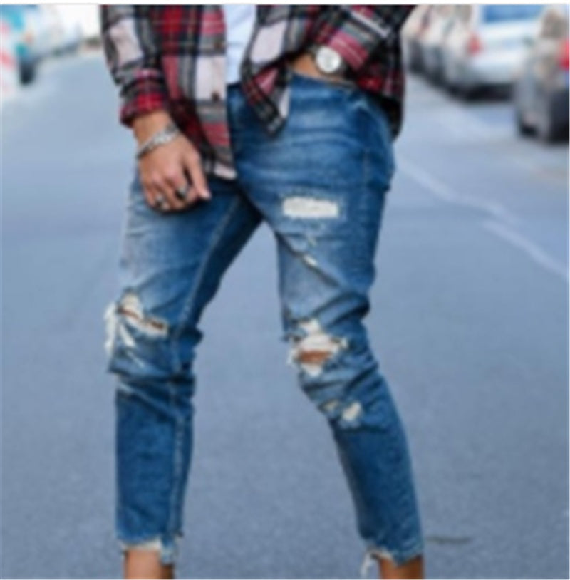 Front view of deep blue distressed jeans with torn knee patches and frayed edges